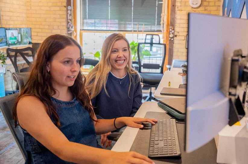 Two AdShark team members working together at a monitor