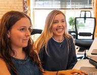 Two AdShark designers collaborating at a workstation