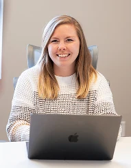 An AdShark team member working on a laptop in the meeting room