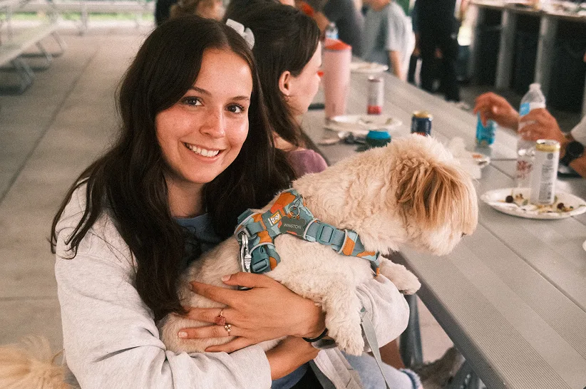 Ellie holding Winston the dog at a team picnic