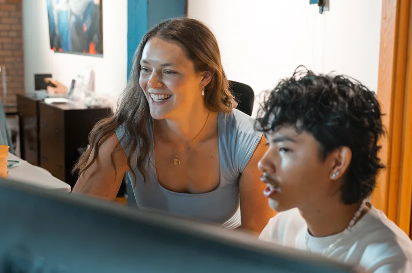 Xyle and Callie reviewing work together at a monitor