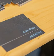 AdShark business cards on a wooden desk