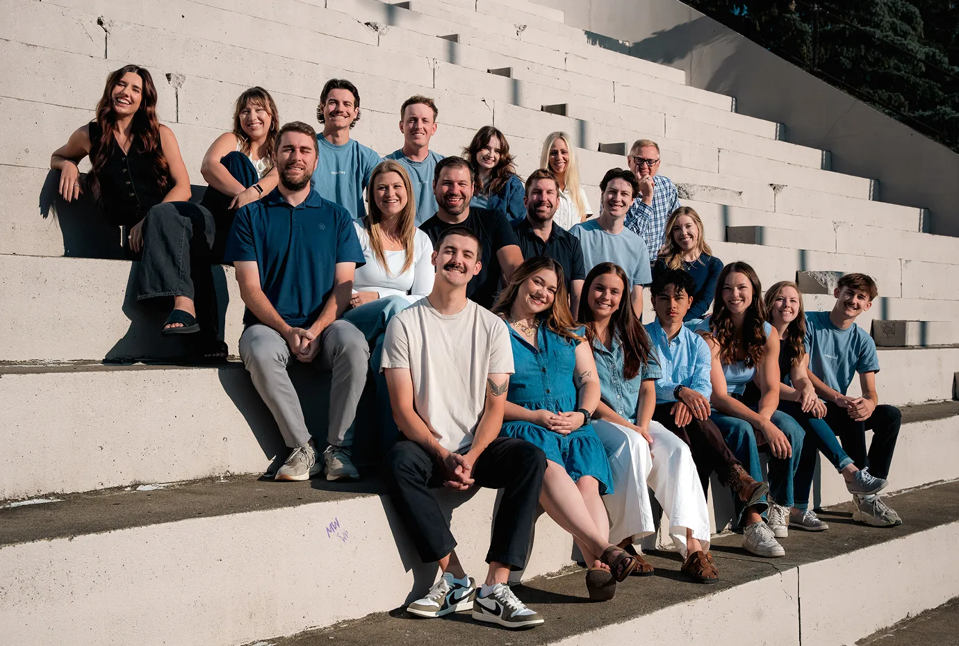 The AdShark team sitting together on outdoor concrete steps