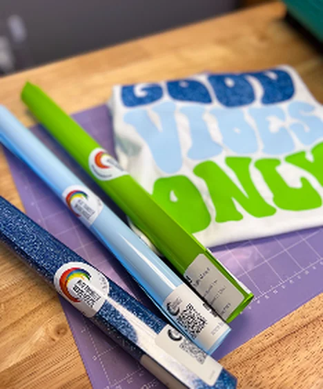Heat transfer vinyl rolls beside a printed graphic tee