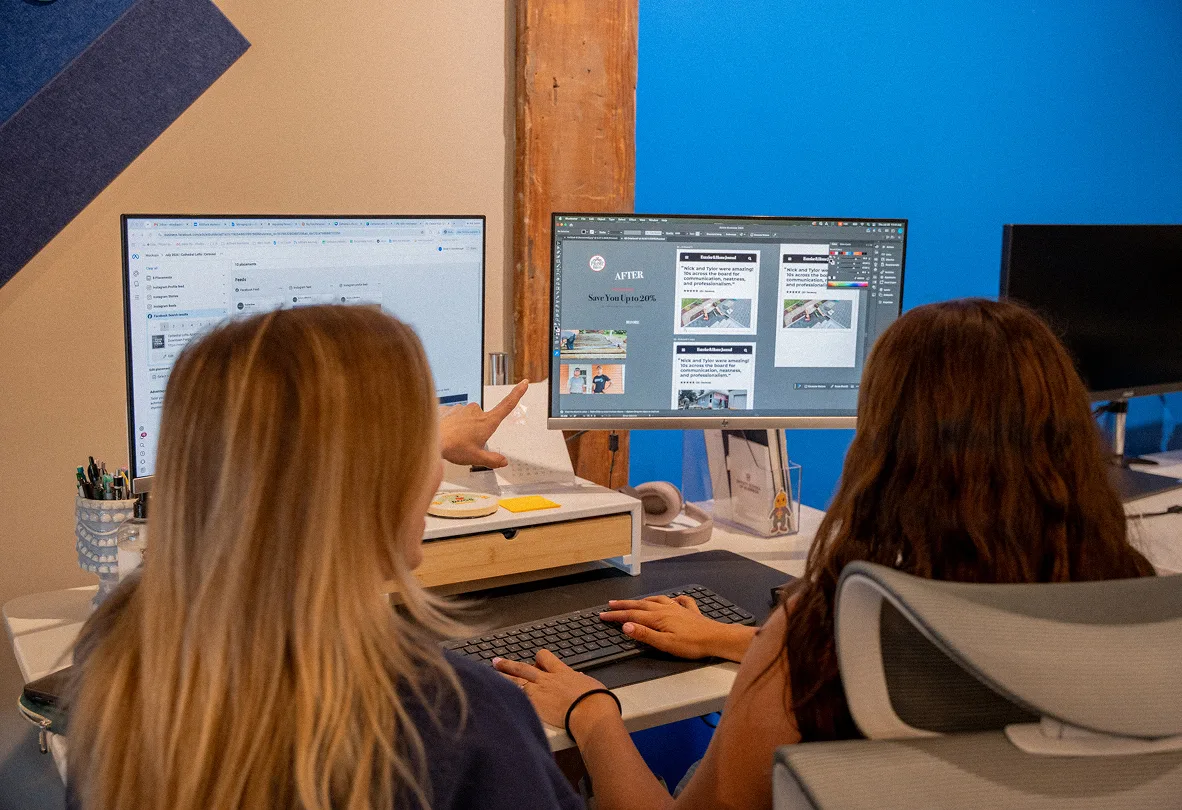 Two AdShark team members reviewing ad creative together at their desks