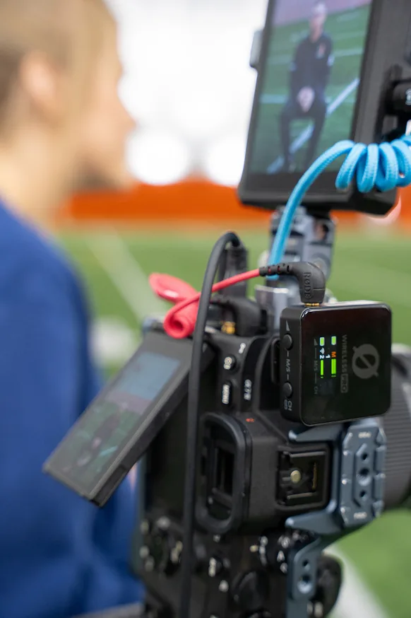 A camera rig with wireless audio monitoring a sideline interview