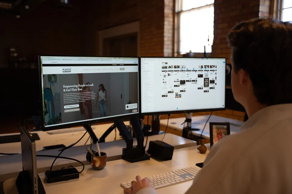 An AdShark-built website on a dual-monitor workstation